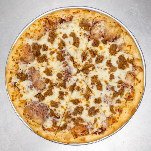 A whole round pizza with white cheese and crumbled sausage, sliced into eight pieces.